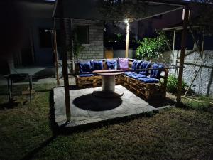 a table and couch in a backyard at night at Velipoja Home in Velipojë