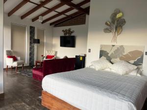 a bedroom with a white bed and a living room at Quinta Elvira Rose in Checa