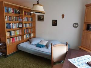 a small bed in a room with book shelves at Wellcome in Evita House in Dassel
