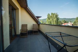 a balcony with chairs and a table on a building at Apartmá Kateřina Velké Losiny in Velké Losiny