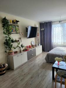 a bedroom with white cabinets and a bed and a table at Oxy appart in Ventspils
