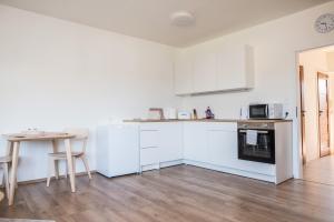 a kitchen with white appliances and a table in a room at Apartmá Kateřina Velké Losiny in Velké Losiny