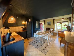 a kitchen and living room with a table and chairs at Cottage du collectionneur in Saint-Laurent-du-Mottay