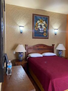 a bedroom with a bed with two tables and two lamps at HOTEL COLONIAL MATAMOROS in Matamoros +22 photos