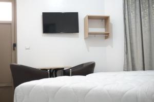 Una habitación con una cama y un televisor de pantalla plana. en Hôtel Nakhil Dak Hay Salam, en Dakhla