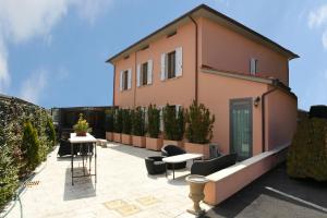 eine Terrasse mit Stühlen und Tischen sowie ein Haus in der Unterkunft Hotel Il Monte in Monte San Savino