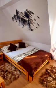 a bedroom with a bed with a mountain mural on the wall at Pokoje "U Moniki" in Ząb