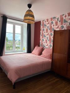 a bedroom with a large bed with a large window at Vinyle club - Appartement rétro 70's-6 pers in Bellême