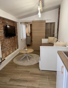 une cuisine et un salon avec un canapé et une table dans l'établissement Escapade Tournefeuille, jacuzzi, balnéo, terrasse, à Tournefeuille