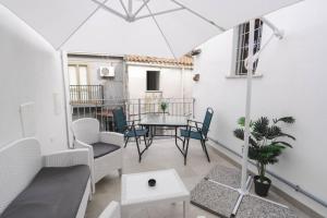 a living room with a table and chairs on a balcony at Dimora Riente Luxury Rooms in Diamante