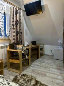 a living room with a table and a tv on the wall at Pokoje "U Moniki" in Ząb