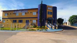 a yellow building with a clock on the side of it at Hotel Akroama in Corumbaíba