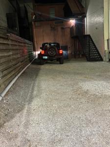 a black jeep parked in a garage at night at In the Heart of Town-3BR-2bath-500Mbps WiFi-4car parking-EV-boat in Florence