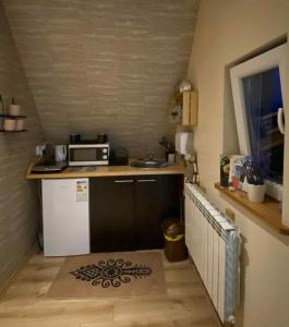 a small kitchen with a sink and a microwave at Pokoje "U Moniki" in Ząb