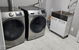 eine Küche mit Waschmaschine und Spüle in der Unterkunft Gracy's property in Thamesford