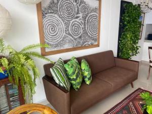 un soggiorno con divano marrone e cuscini verdi di Frente al Mar home office 7B a Cartagena de Indias