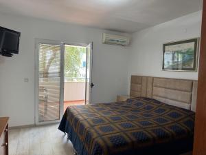 a bedroom with a bed and a sliding glass door at Lyon Apartments in Budva