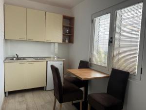 a kitchen with a table and chairs and a kitchen with a sink at Lyon Apartments in Budva