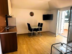 a kitchen with a table and chairs in a room at Lyon Apartments in Budva