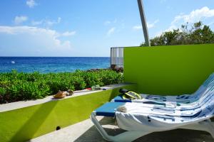 a blue and white chair sitting next to the ocean at Dushi Pietermaai Apartments, DPA in Willemstad