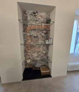 a stone fireplace in a wall with shelves at Casa Edoardo tra Budello e Mare in Alassio