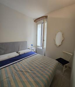 a bedroom with a bed and a mirror on the wall at Casa Edoardo tra Budello e Mare in Alassio