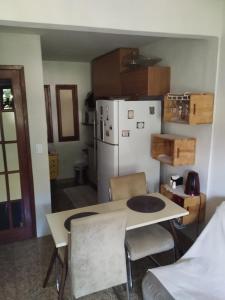 Una cocina con una mesa y un refrigerador blanco. en Apartamento aconchegante!, en Cachoeiro de Itapemirim