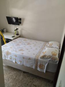 Un dormitorio con una cama y un escritorio con televisión. en Apartamento aconchegante!, en Cachoeiro de Itapemirim