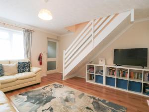 a living room with a couch and a tv at Jay Cottage in Weymouth