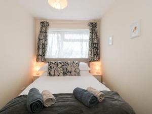 a bedroom with a bed with two towels on it at Jay Cottage in Weymouth