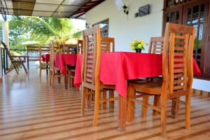 Un comedor con una mesa y sillas rojas. en Freedom Lodge Yala, en Tissamaharama 49 fotos más