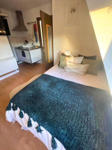 a bedroom with a bed with a blue blanket on it at Bright studio in Excellent location in London