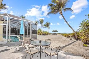 a patio with a table and chairs and a view of the ocean at Waters Edge in Sanibel