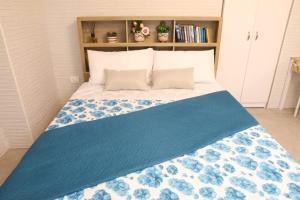 a bedroom with a bed with a blue blanket on it at La Rosa di Antonio -Relax Room in Tricase +6 photos