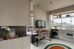a kitchen with white cabinets and a table with chairs at Loft Quero-Quero in Águas Claras