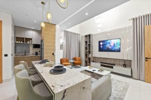 a living room with a dining table and a tv at Luxury 2 Bed in Lagos