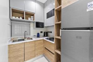 Una cocina con gabinetes de madera y un refrigerador de acero inoxidable. en Luxury 2 Bed, en Lagos 5 fotos más