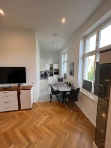 a living room with a table and a kitchen at Exklusive Altbauwohnung mit Arbeitsplatz WE5 in Halle an der Saale