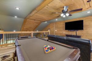 a pool table in a living room with a ceiling fan at Running Bear chalet in Gatlinburg
