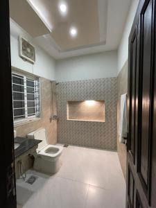 a bathroom with a toilet and a sink at Islamabad Family Residence in Islamabad