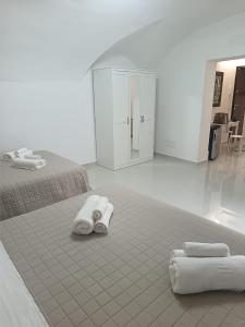1 dormitorio con 2 camas y toallas en el suelo en Al Fiko Suite, en Catania