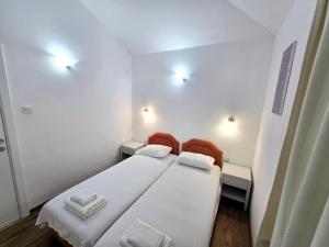 a small room with two beds and two lights at Olive trees in Budva +15 photos