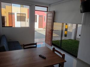 a dining room with a table and a window at casa completa huanchaco con estacionamiento EL REFUGIO SECRETO in Huanchaco