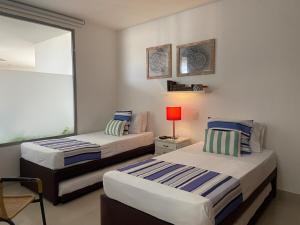 deux lits dans une chambre avec une fenêtre dans l'établissement Alta Mar Ocean Sky, à Carthagène des Indes