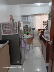 a kitchen with a refrigerator and a table in it at Naybe's Condo rentals in Mandaue City +7 photos