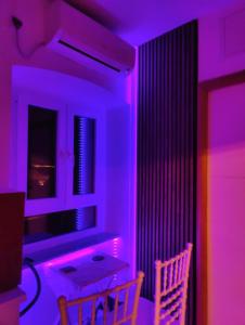 a room with purple lights and a table and two chairs at Marija in Kaštela