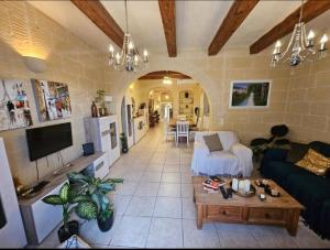 a living room with a couch and a table at Villa Ambrose Village in San Lawrenz