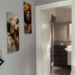two paintings on the wall of a bathroom at La Casina sul Tetto in Albano Laziale +14 photos