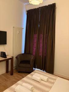 a living room with a chair and a window at The Angelico Rooms in Rome