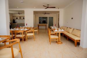 a dining room with wooden tables and a couch at Premier Hotel Zanzibar Airport in Zanzibar City